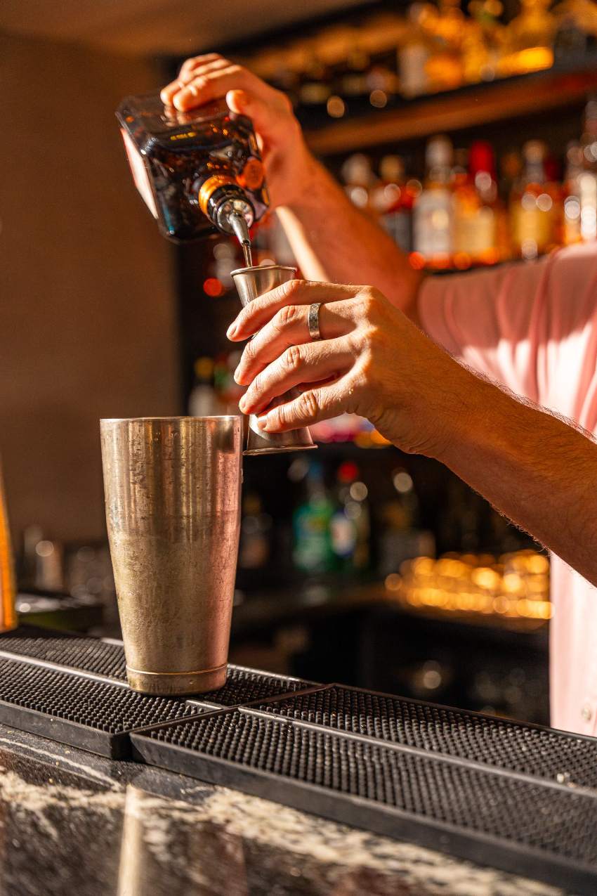 A cocktail being poured at the bar